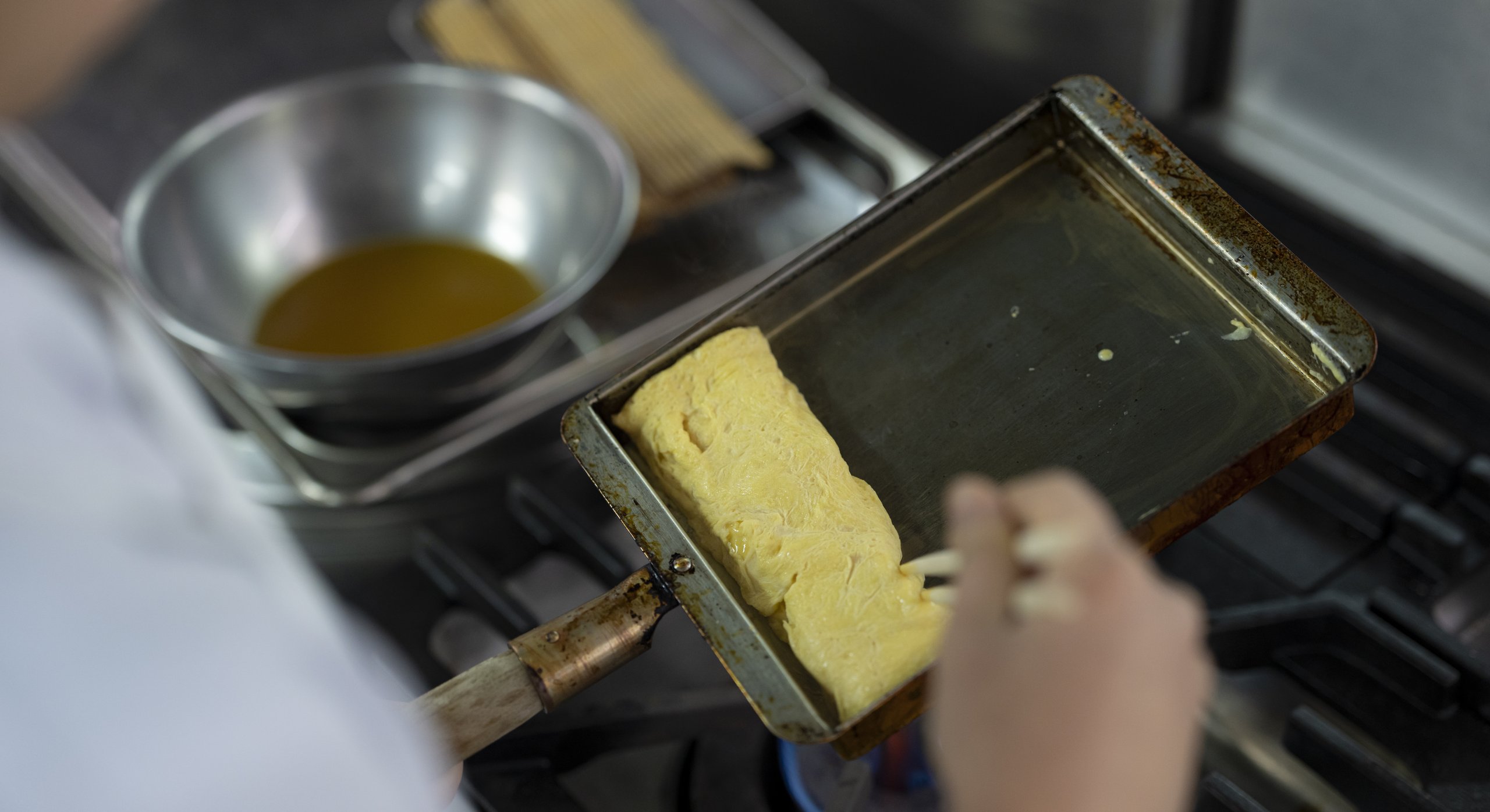 卵焼き器で玉子焼きを焼く手元