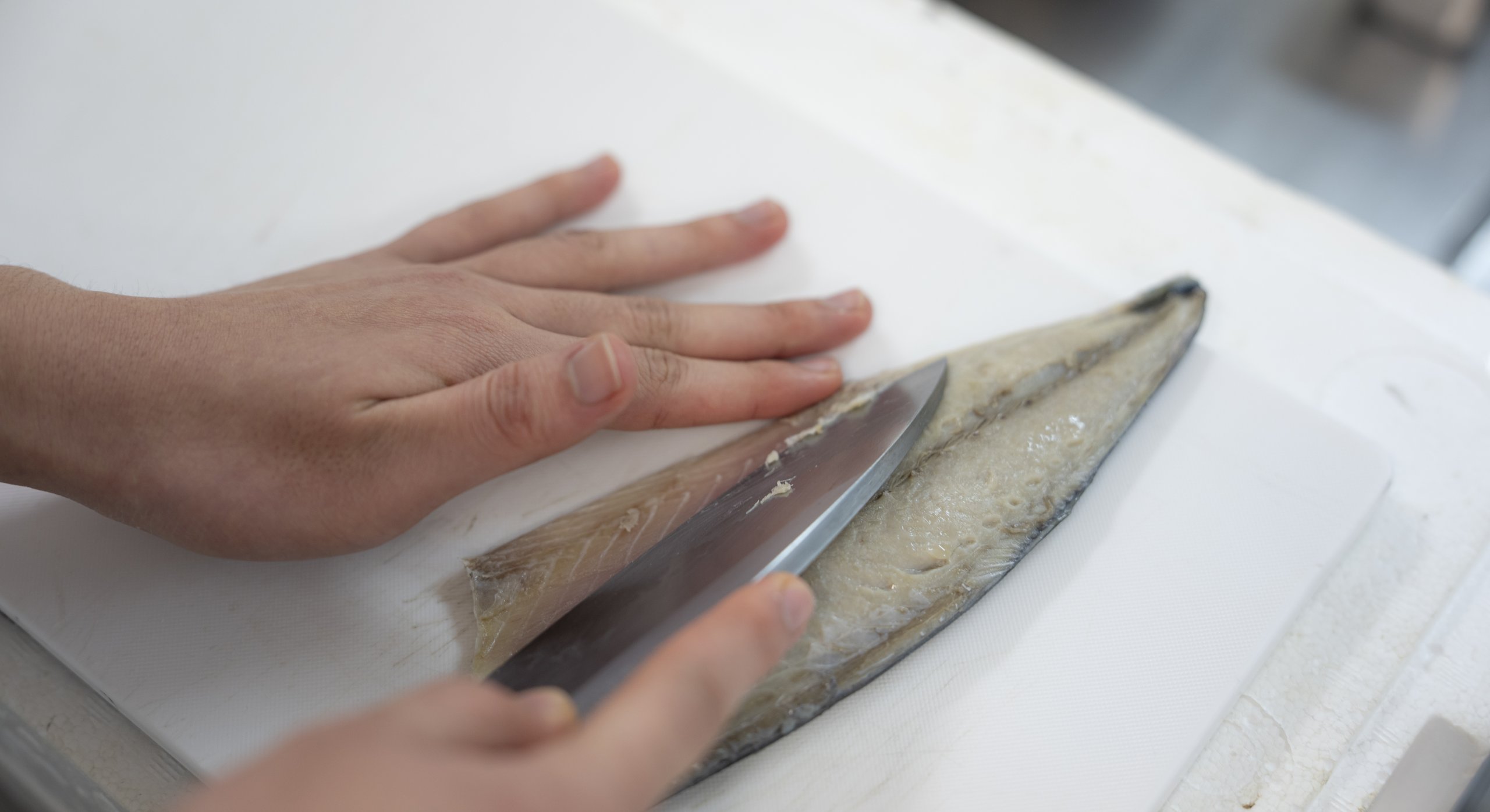 まな板の上で魚をおろす手元